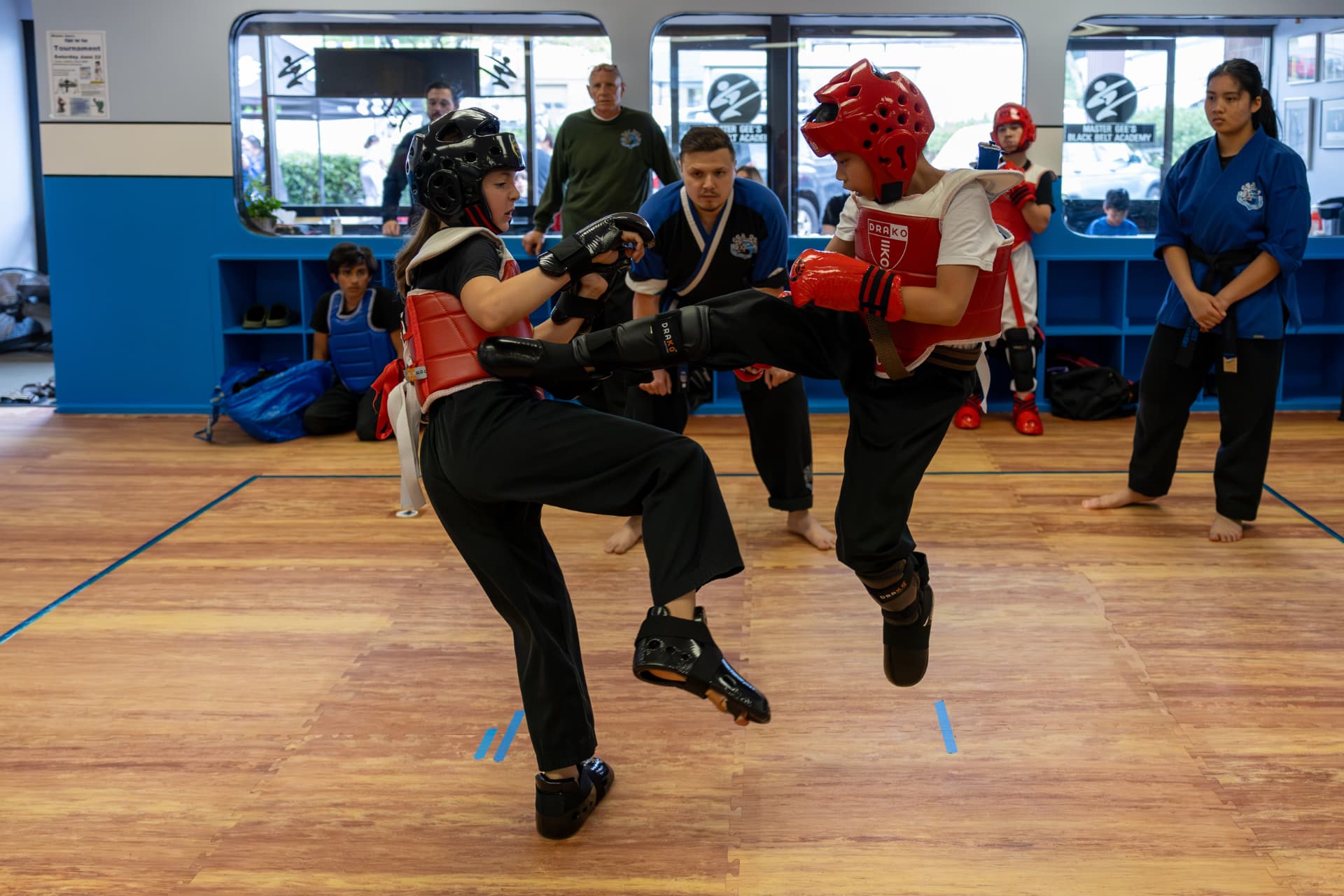 Junior sparring match with instructors watching