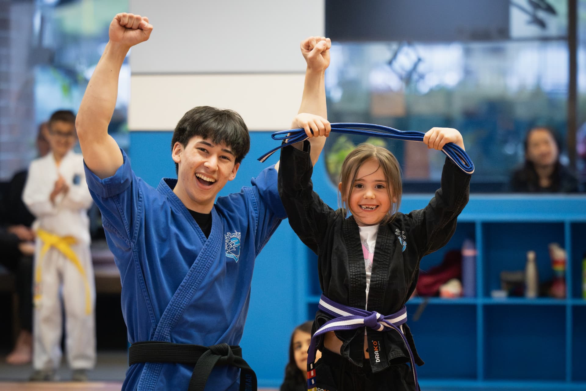 Instructor celebrating a student's blue belt