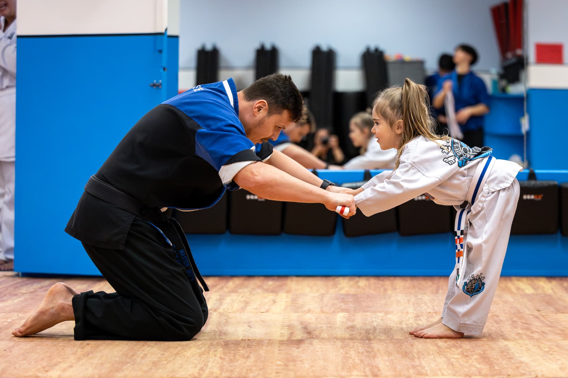 Instructor kneeling with a young Tigers student