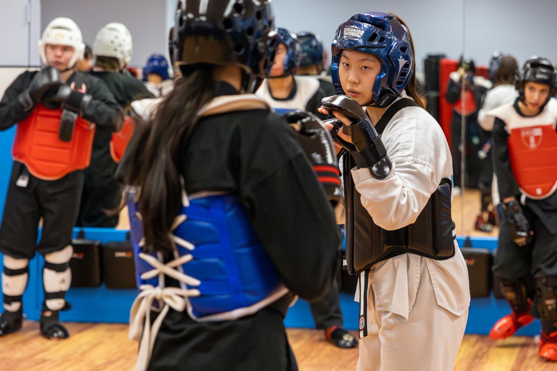 Adult students facing off in sparring gear