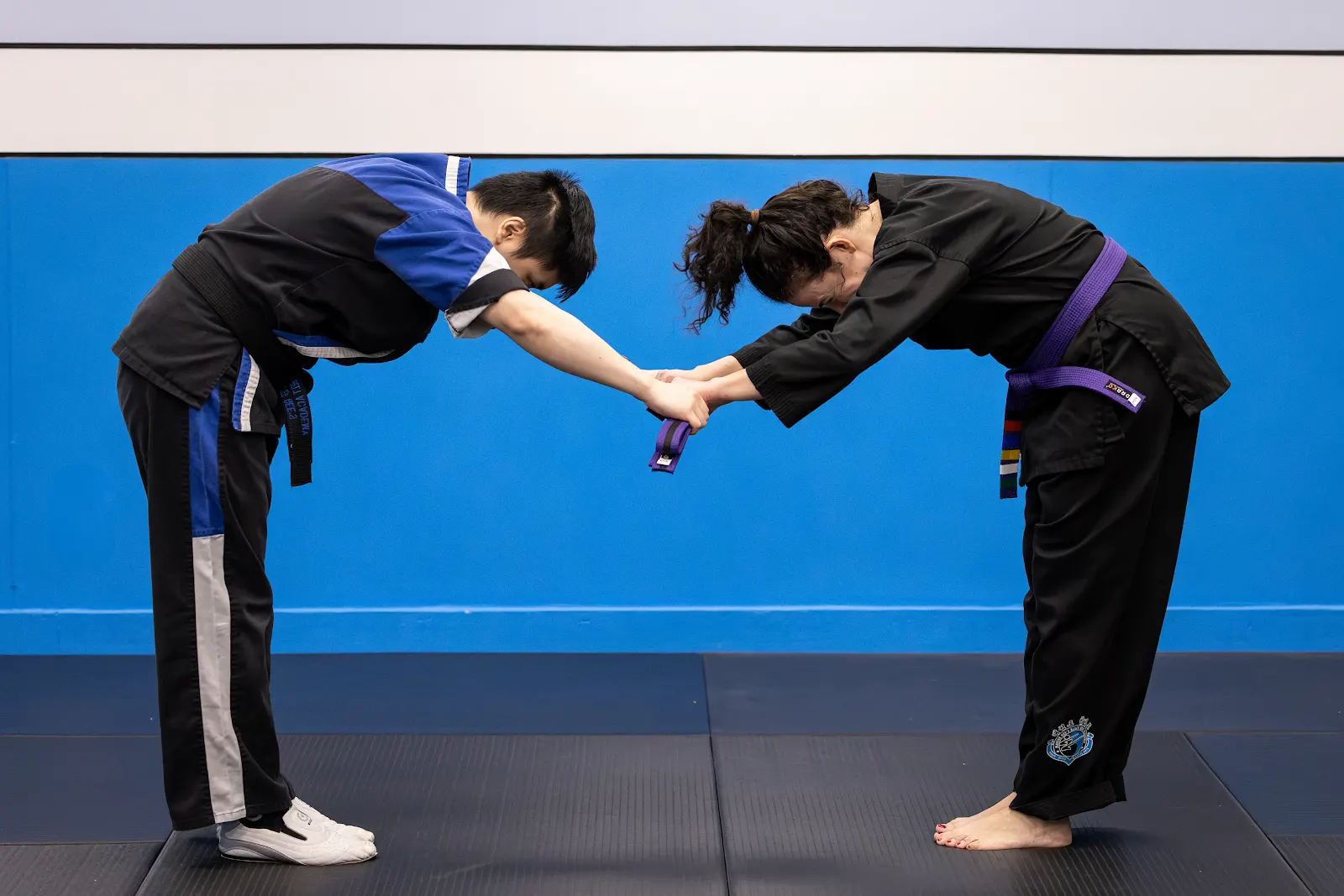 Students bowing while receiving a purple belt