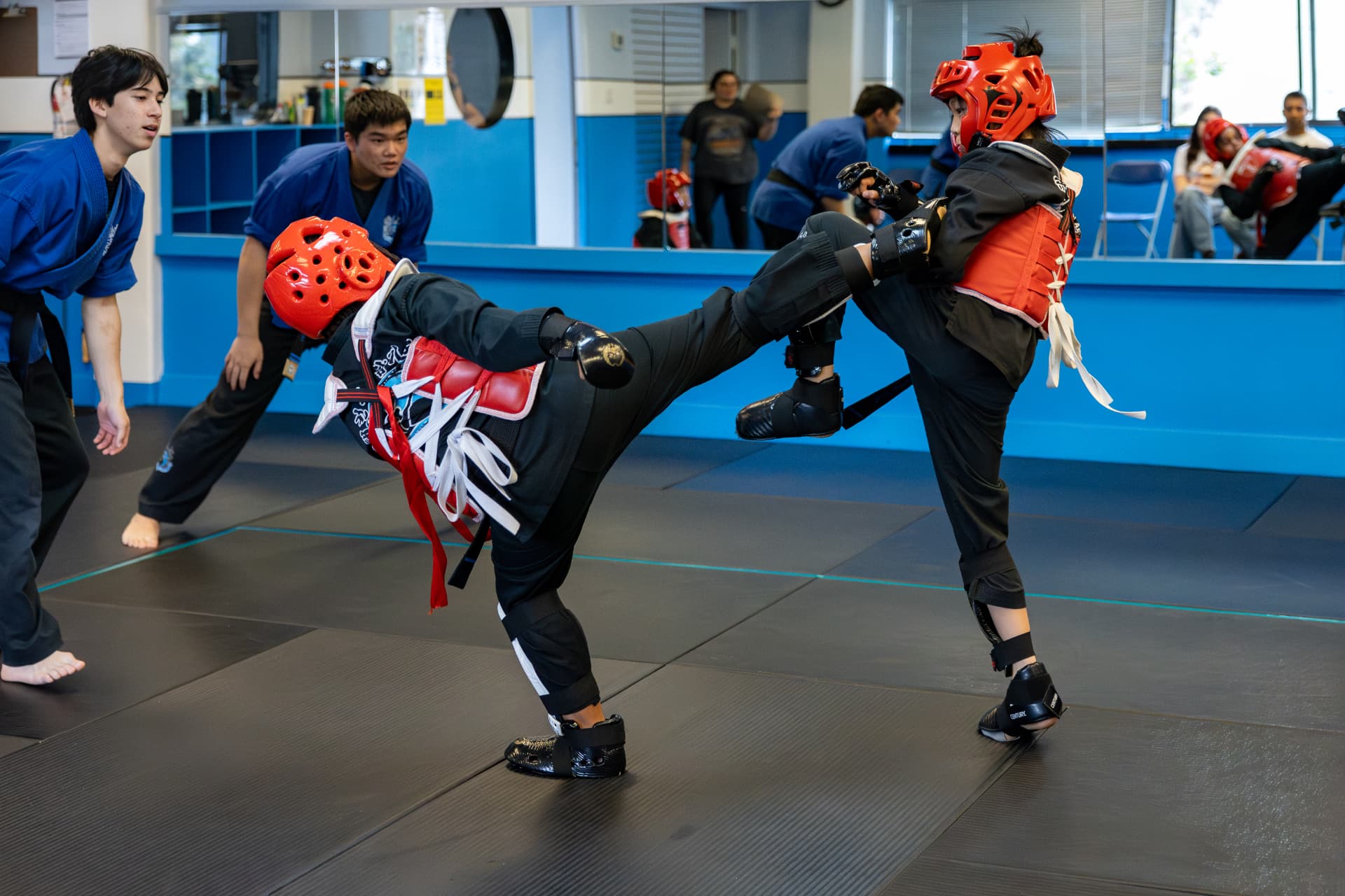 Junior students sparring with head and body gear